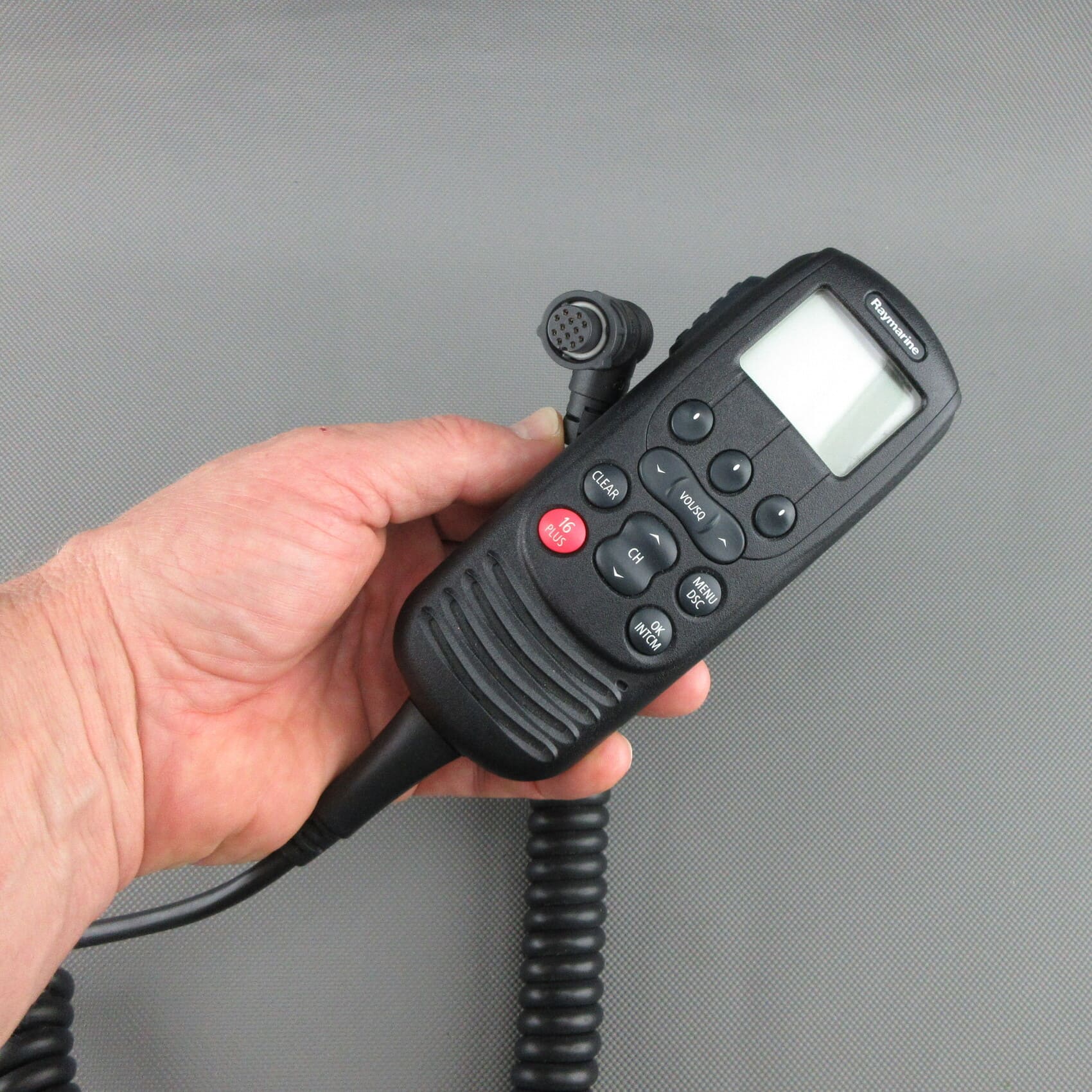 Vue de face du combiné VHF Raymarine® Ray260 A80197 reconditionné, tenu en main, montrant la face avant et la prise de connexion.