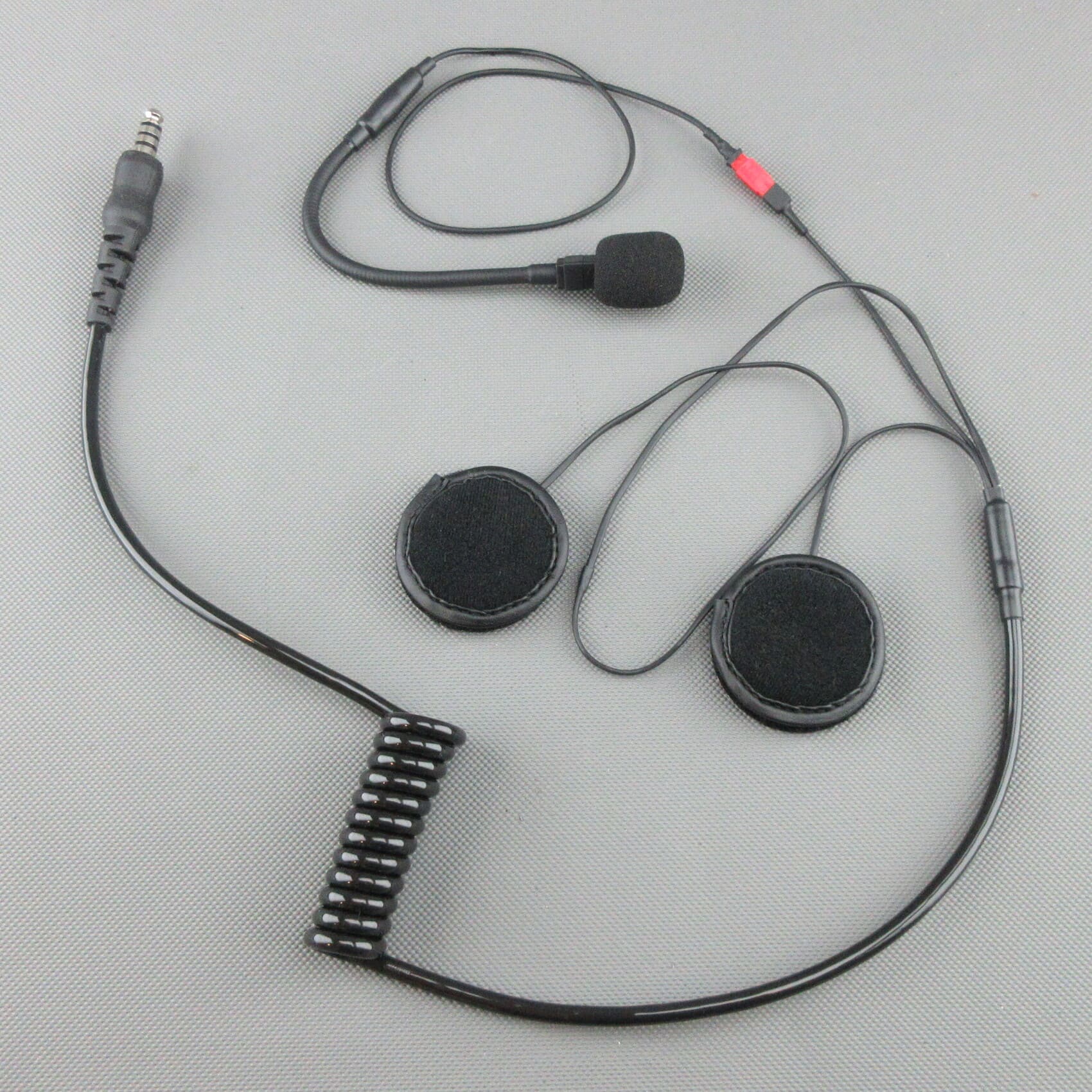 L'image montre un kit d'installation pour casque de sport automobile jet comprenant des haut-parleurs, un micro col-de-cygne, un câble de connexion spiralé et une fiche jack TP-120 avec câblage compatible Peltor®.